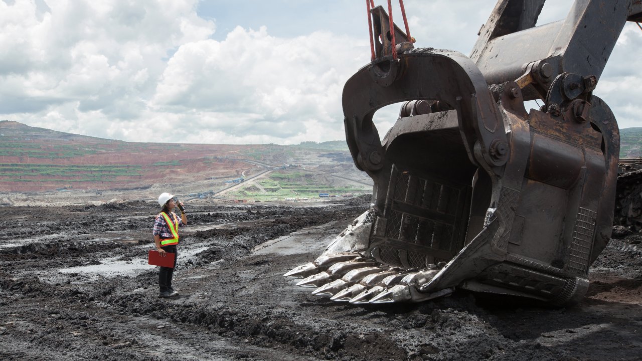 Large Mining shovel next to person inspecting
