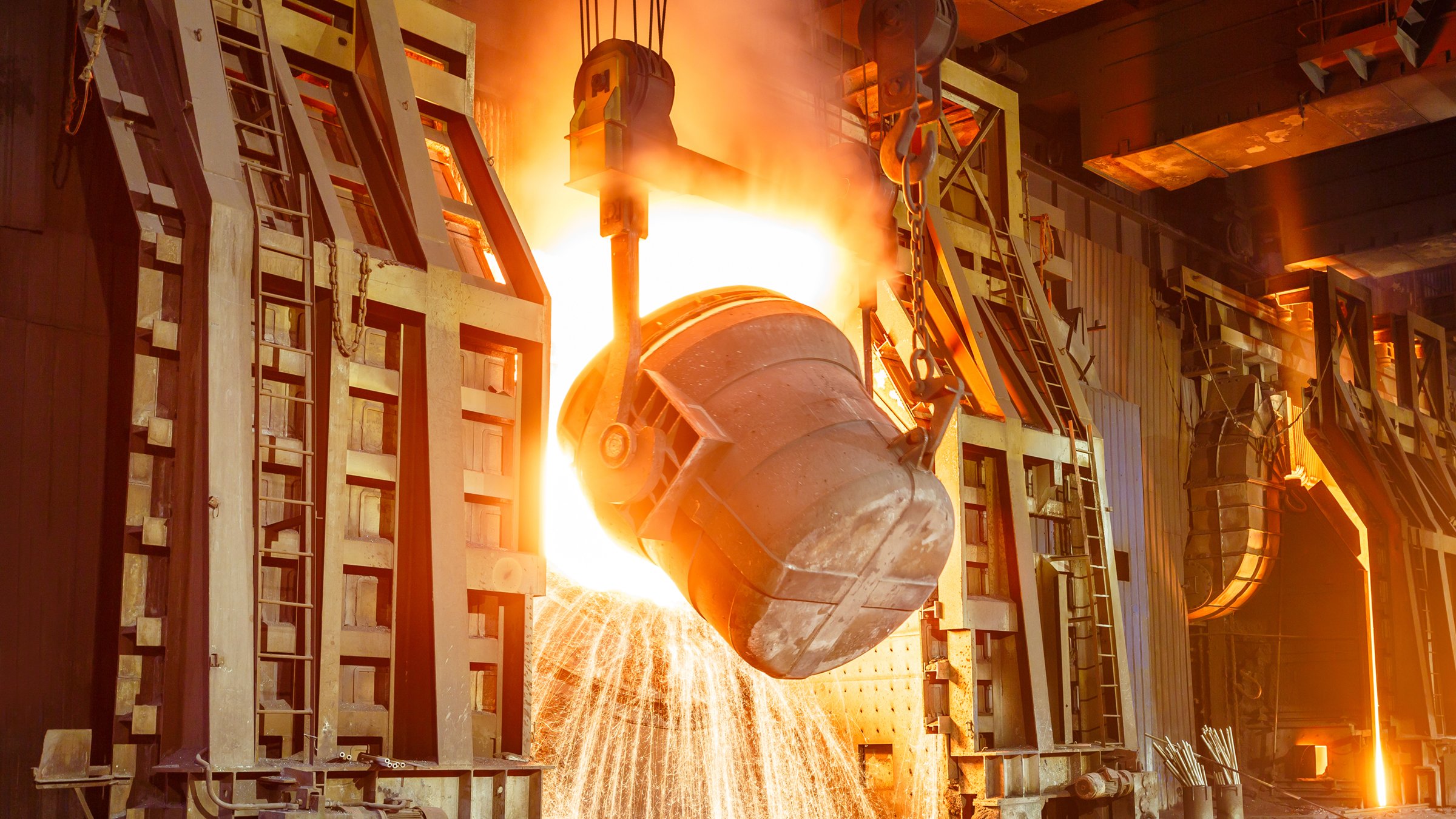 Bucket pouring raw materials into smelter