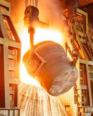 Bucket pouring raw materials into smelter