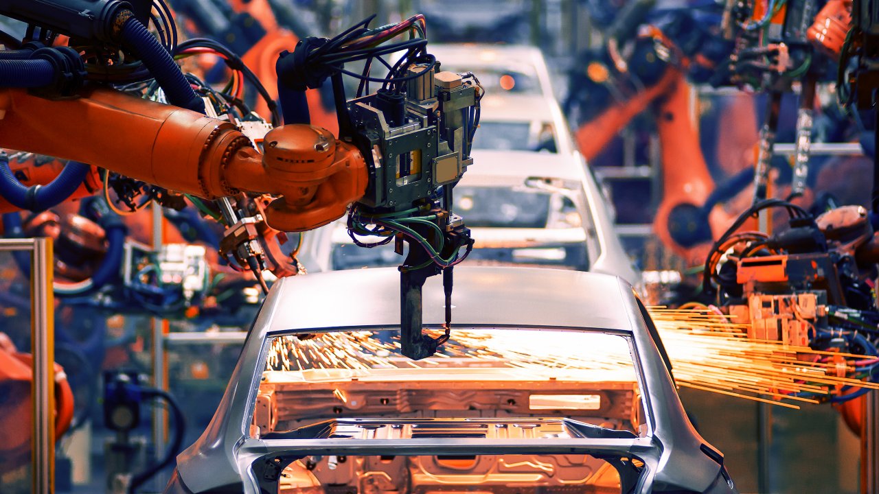 Robotic arms on assembly line making cars