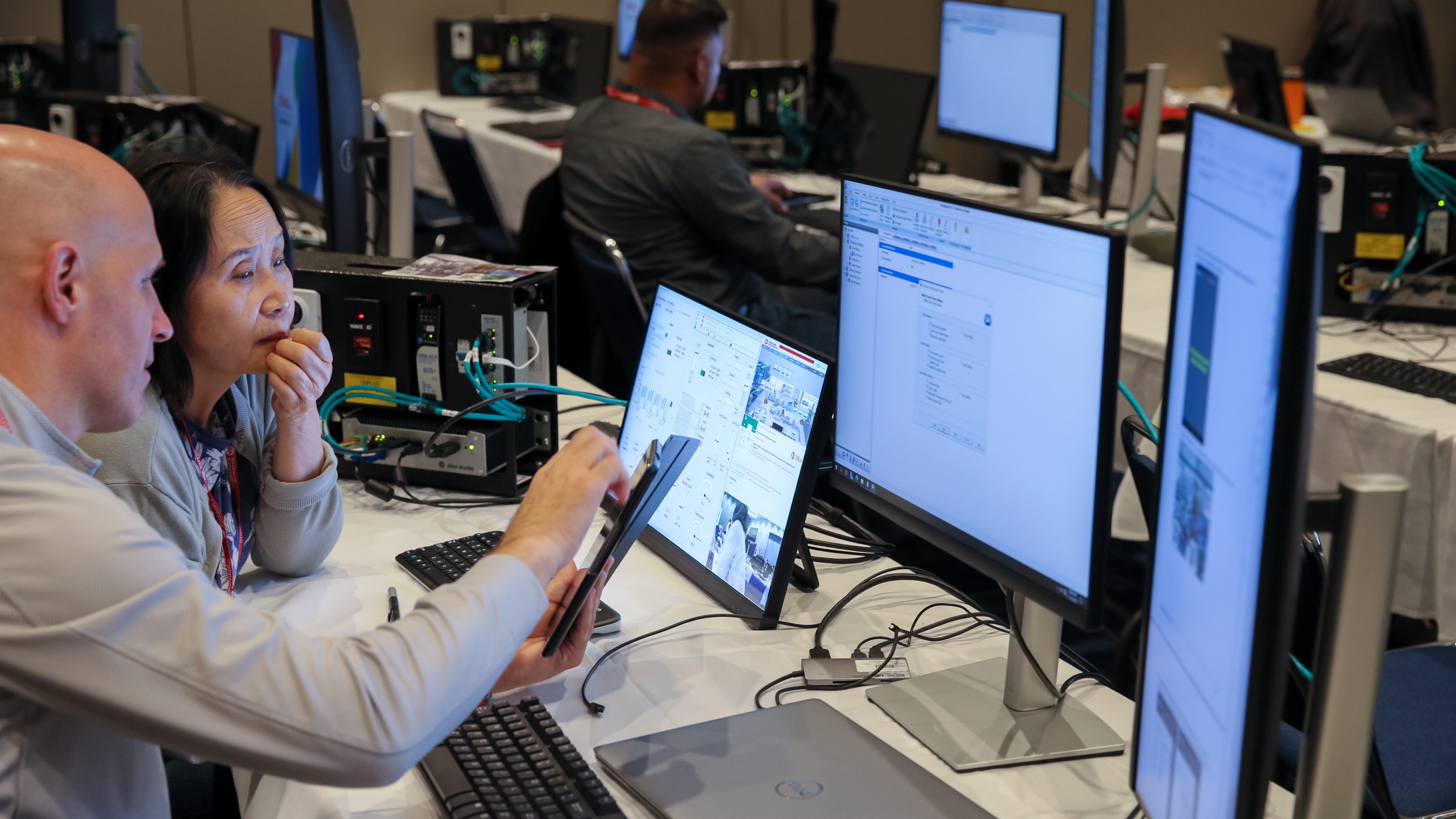 Woman in foreground of Hands-On-Labs session with other attendees in background.