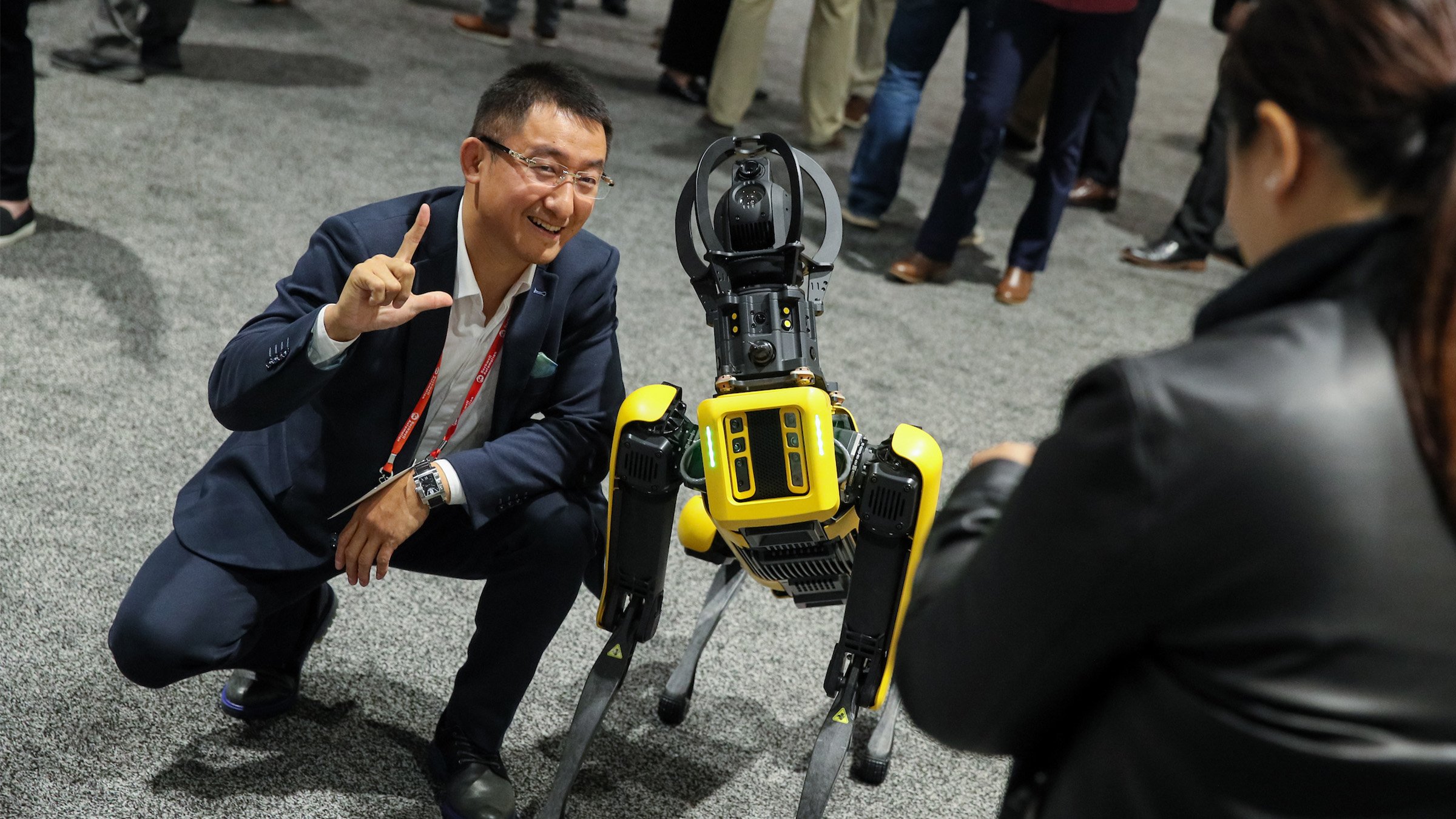 A man poses for a picture with a robot at the Automation Fair expo