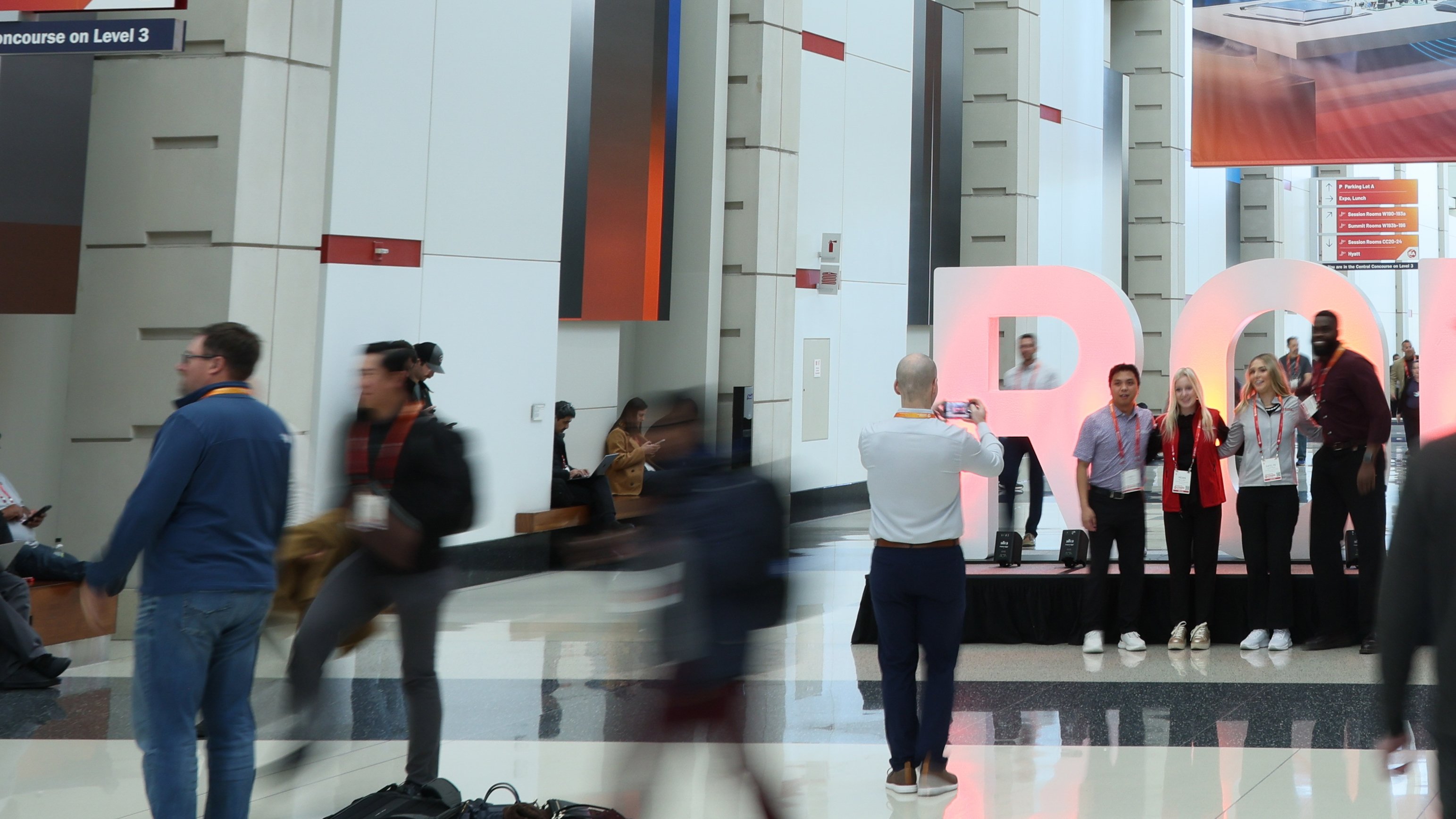 A group of people getting their picture taken in front of the ROK letters at Automation Fair