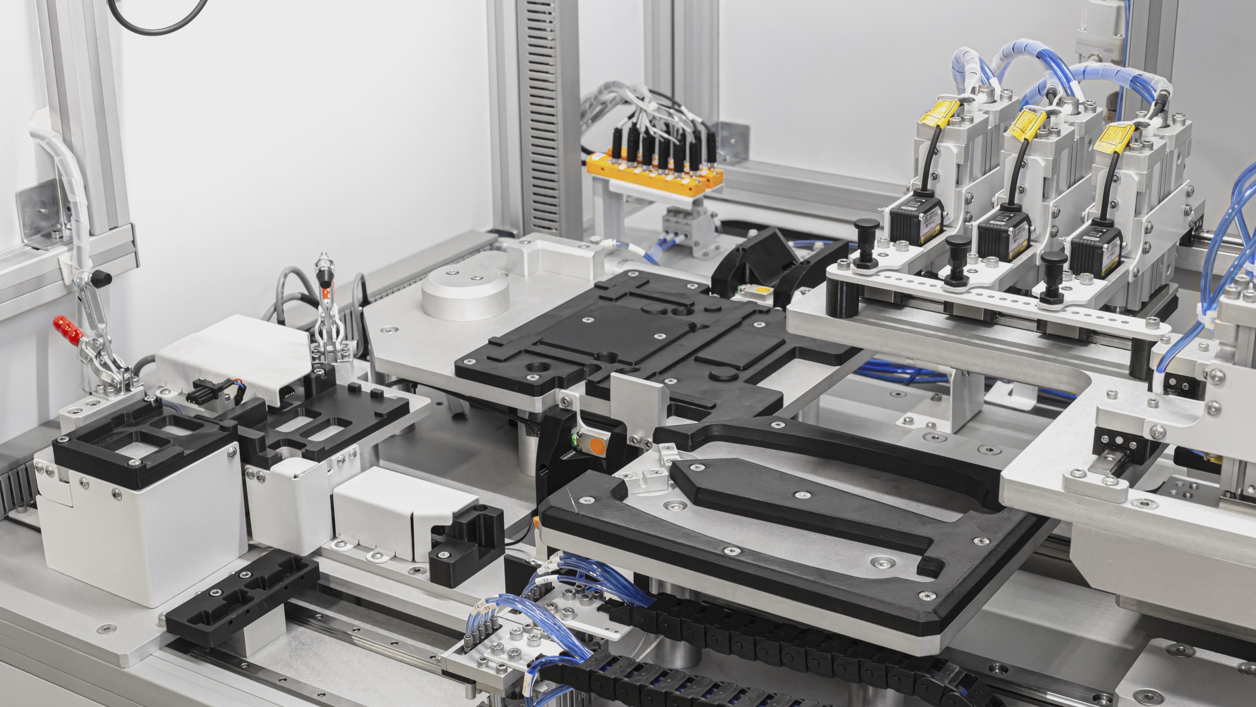 Maquinaria industrial de alta precisión con componentes de ensamblaje automatizado, fijaciones neumáticas y cableado técnico