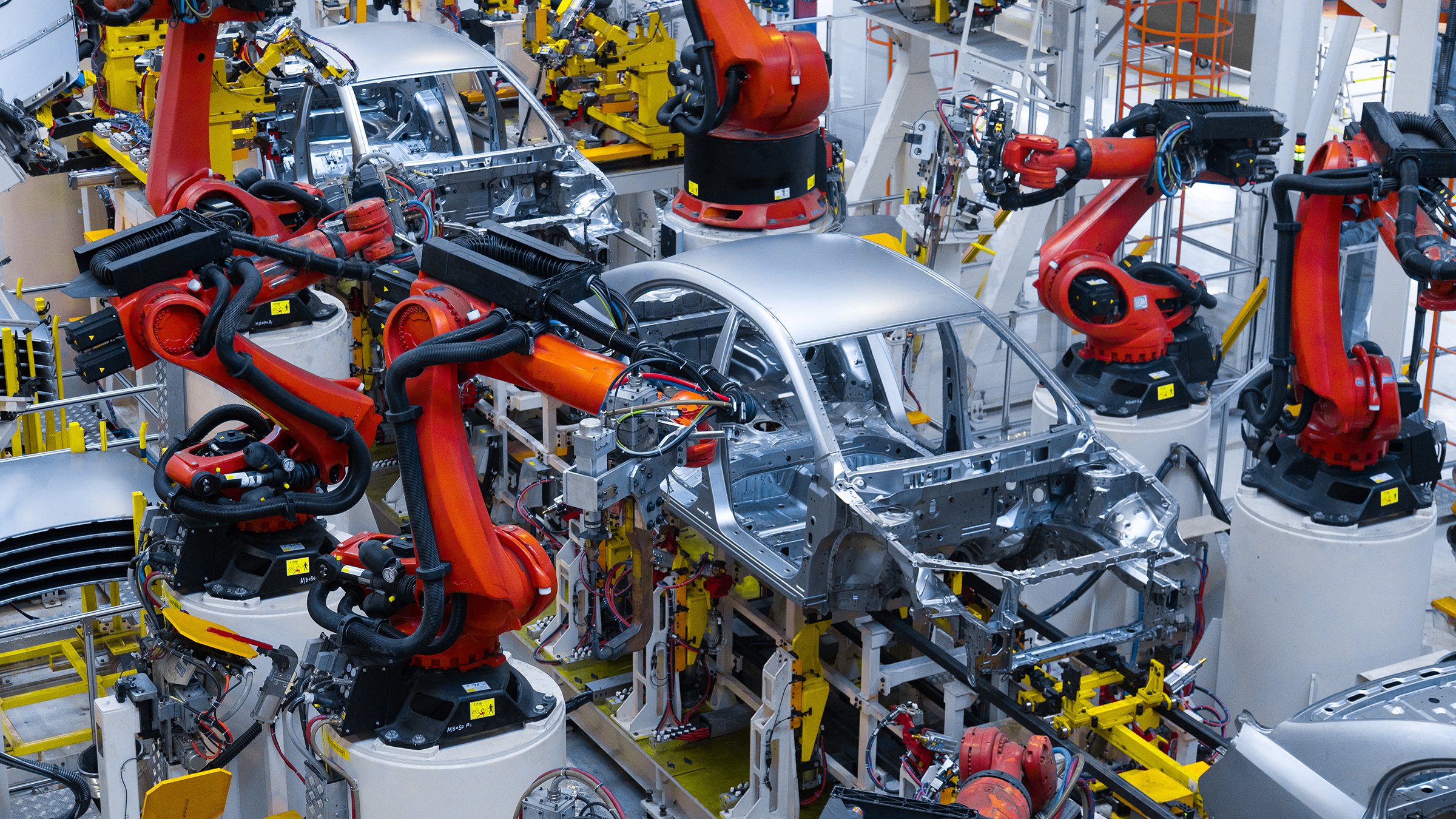 Cars being assembled with robots on automobile assembly line