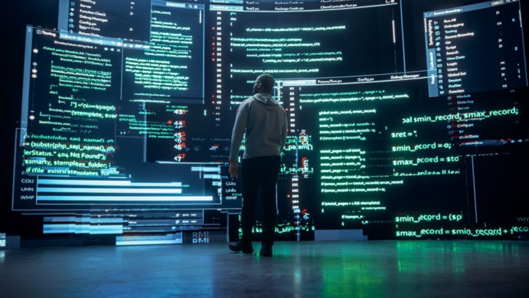 Back View of Young Black Man Walking and Looking at Big Digital Screens Glitching While Displaying Code Lines. Professional Hacker Breaking Through Cybersecurity Protection System, Changing Code