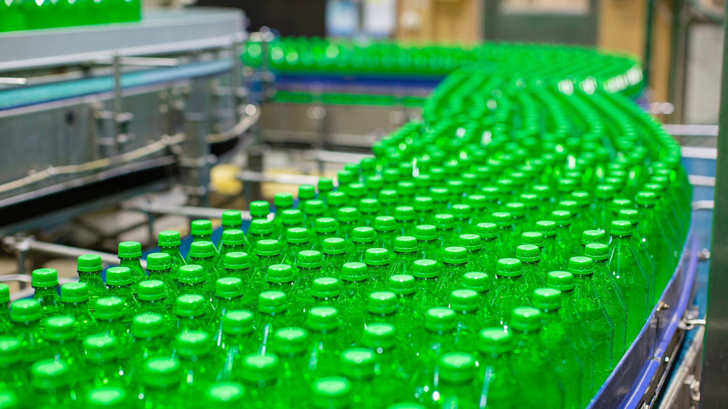 Beverage factory interior. Conveyor  with green bottles.