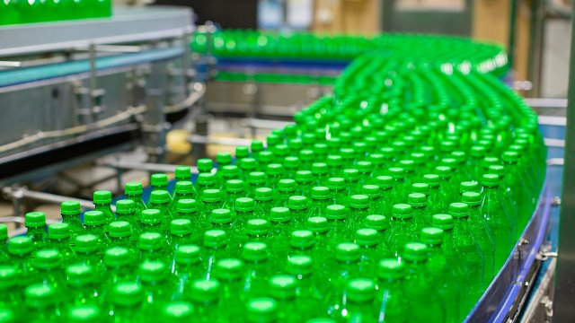 Beverage factory interior. Conveyor  with green bottles.