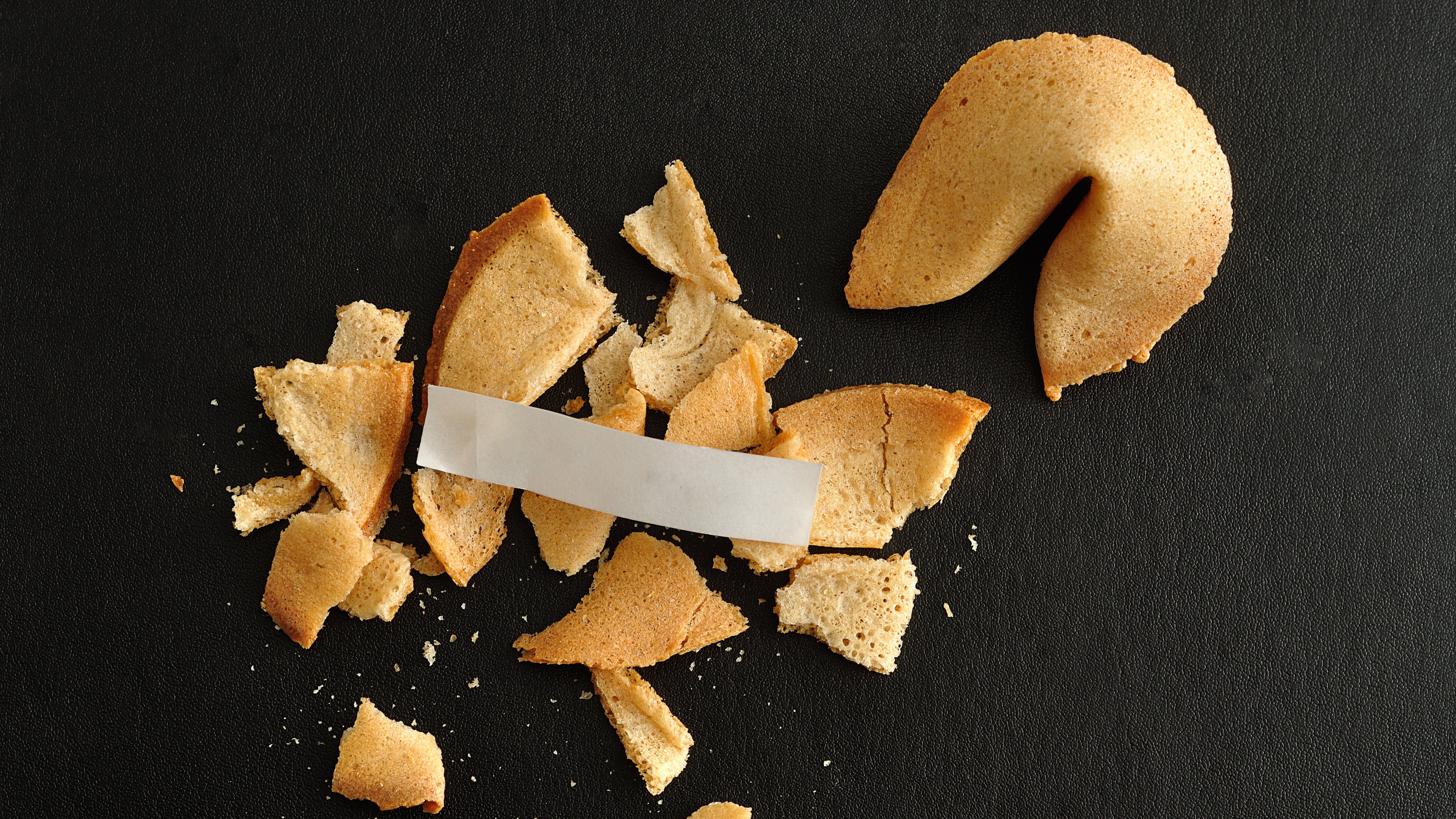 Broken fortune cookie with a piece of paper