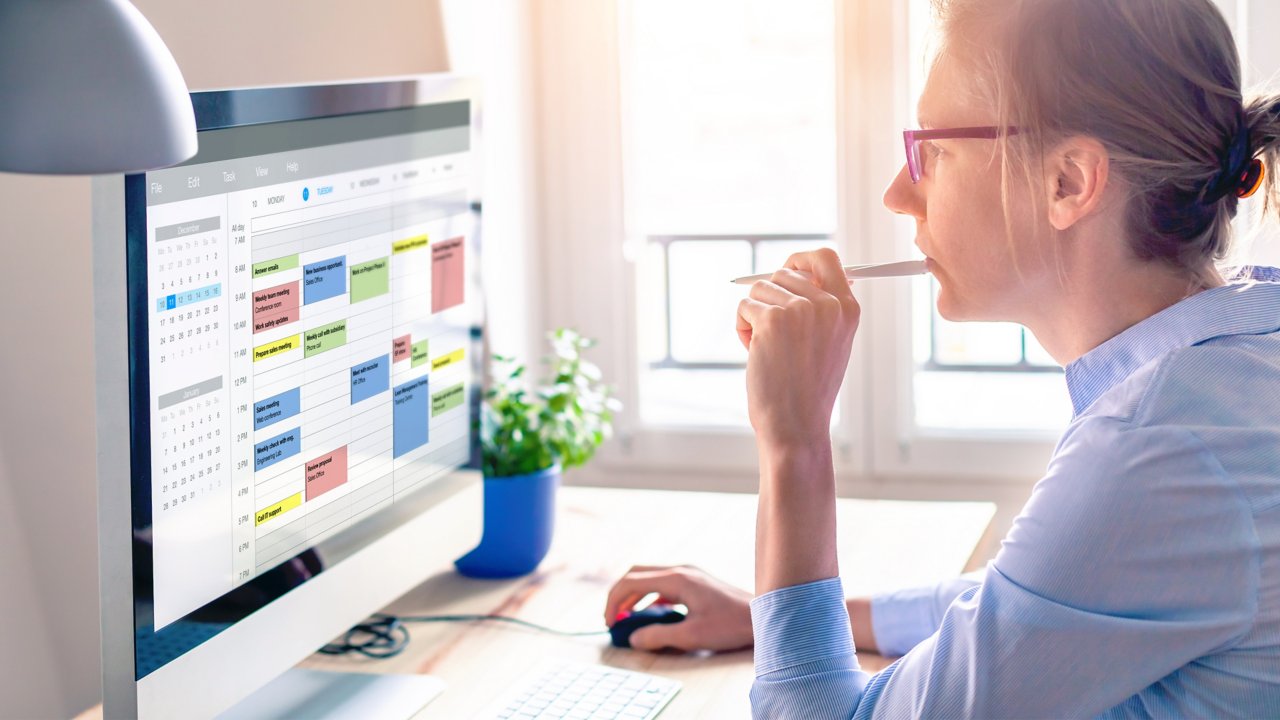 Woman is scheduling meeting using online calendar on her computer