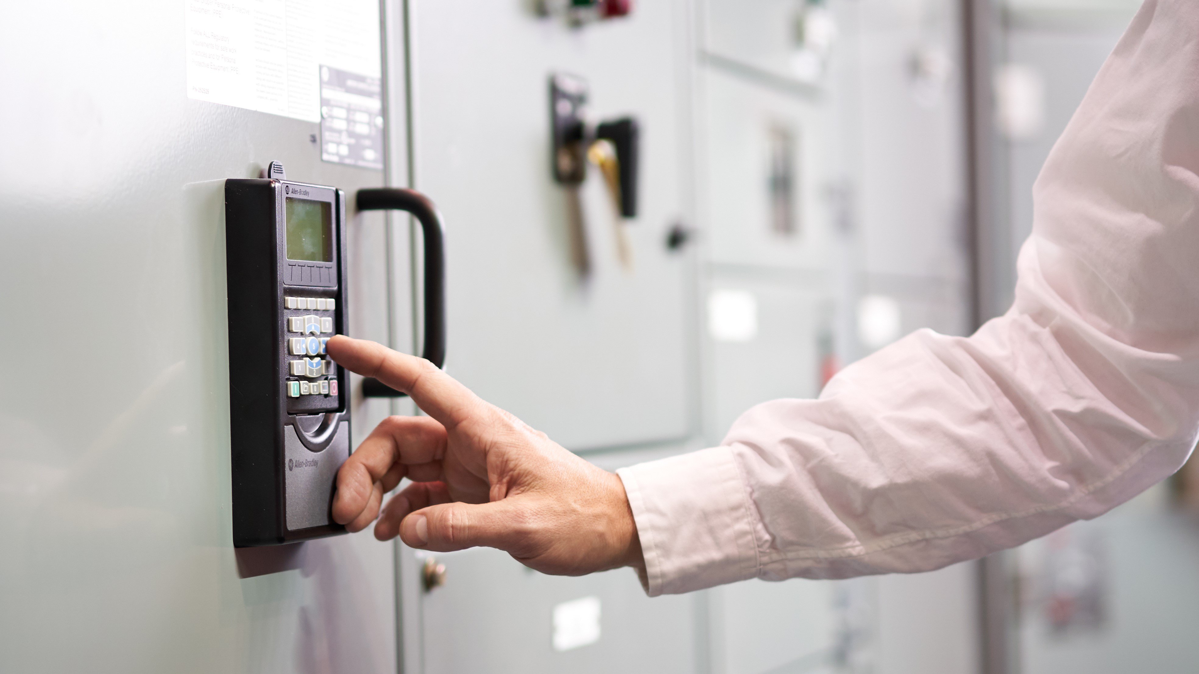 Una persona presionando un botón en un panel eléctrico