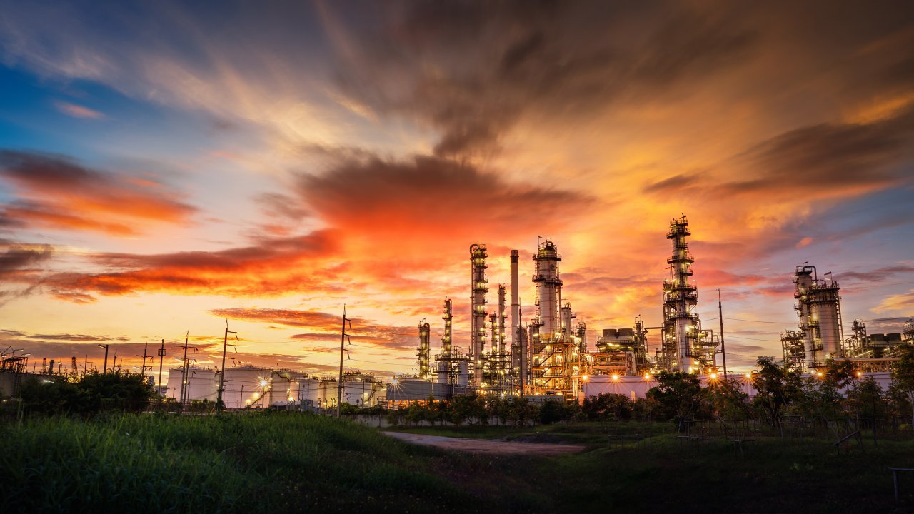 Chemical oil refinery plant, Power plant and metal pipe on red sunrise sky background.