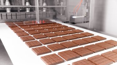 Chocolate sweets candy factory, sweet on conveyor automatic line, top view. Modern manufacturing industry food.