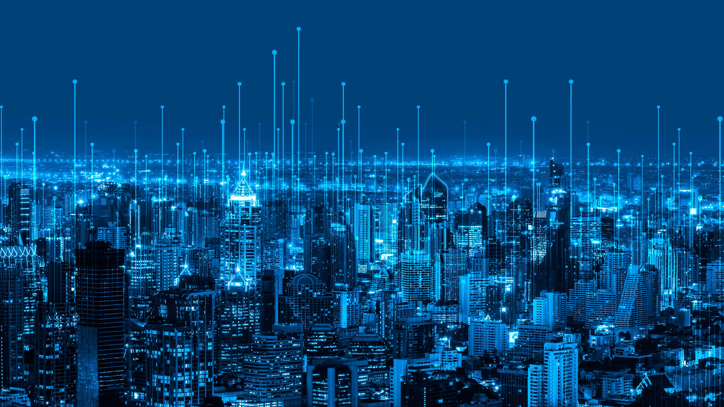 Visão noturna da cidade tecnologicamente avançada com numerosos dispositivos interligados e luzes vibrantes iluminando as ruas e o céu