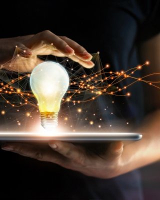Abstract. Innovation. Hands holding tablet with light bulb future technologies and network connection on virtual interface background, innovative technology in science and communication concept 