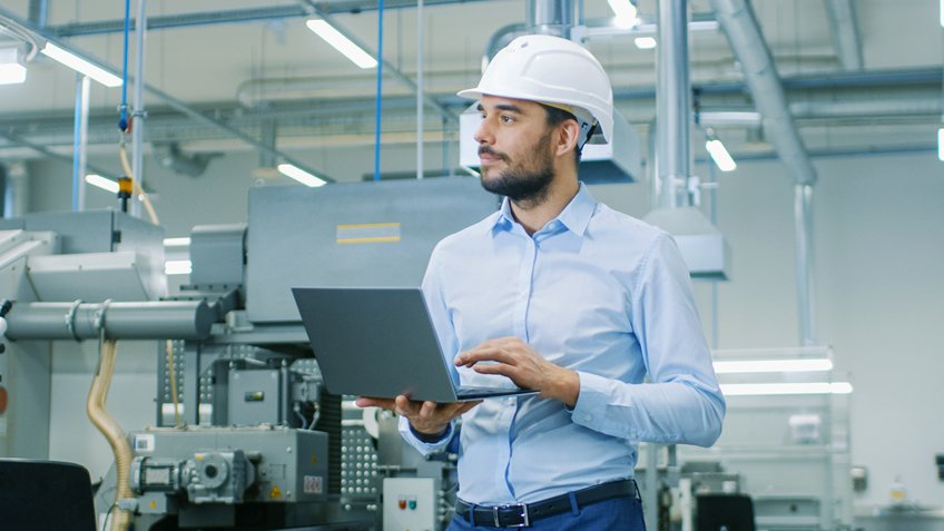 Trabajador con notebook en planta industrial