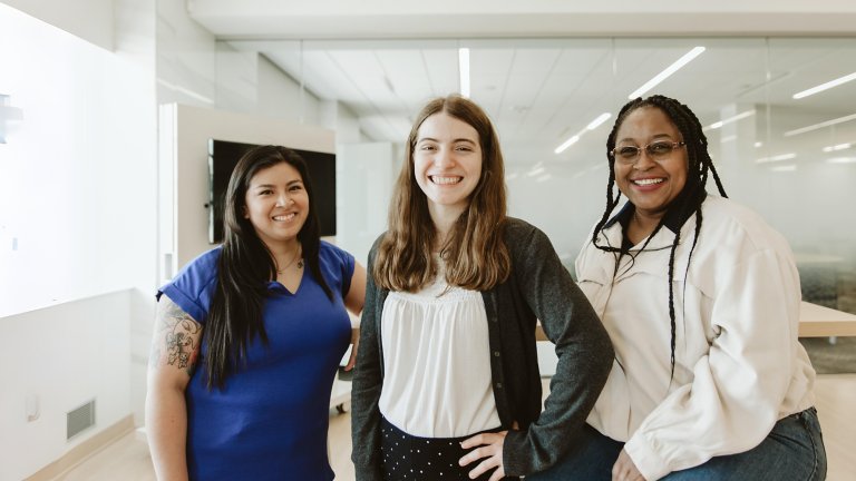 diverse group of three employees posing together for a portrait
