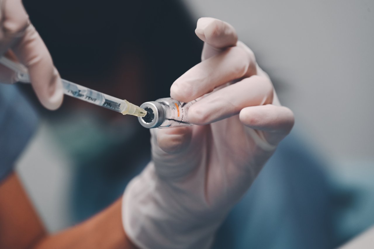 Doctor using a syringe pull medicine