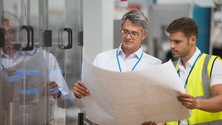 Engineer and project manager looking at blueprint