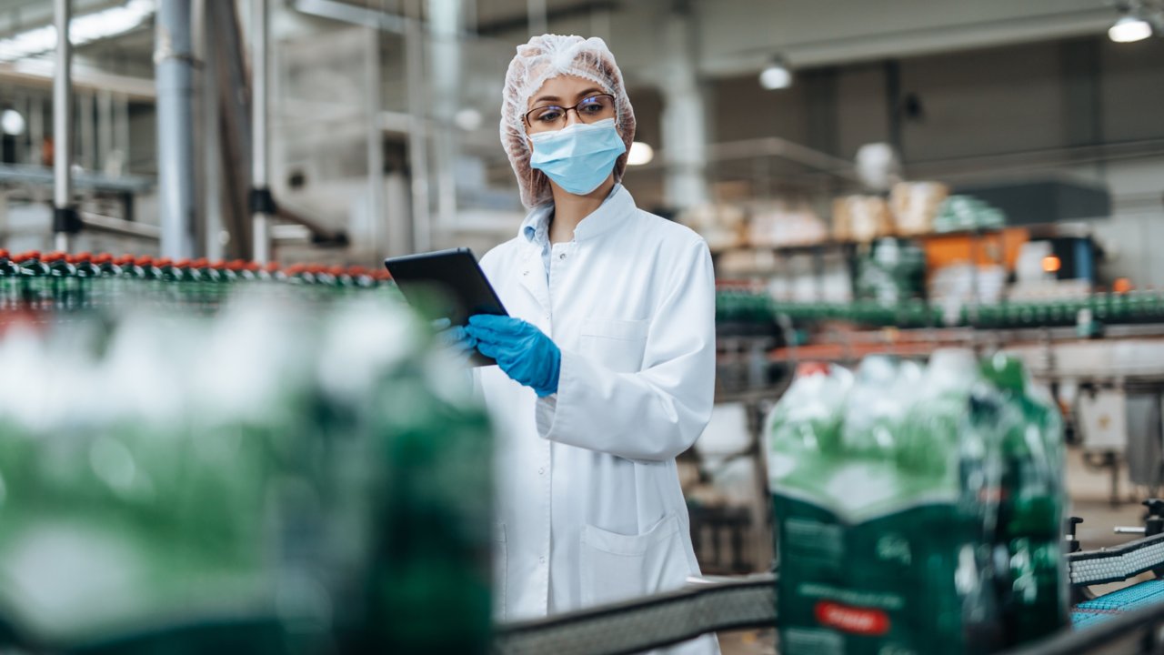 Female engineer performing an inspection quality control in a bottling factory