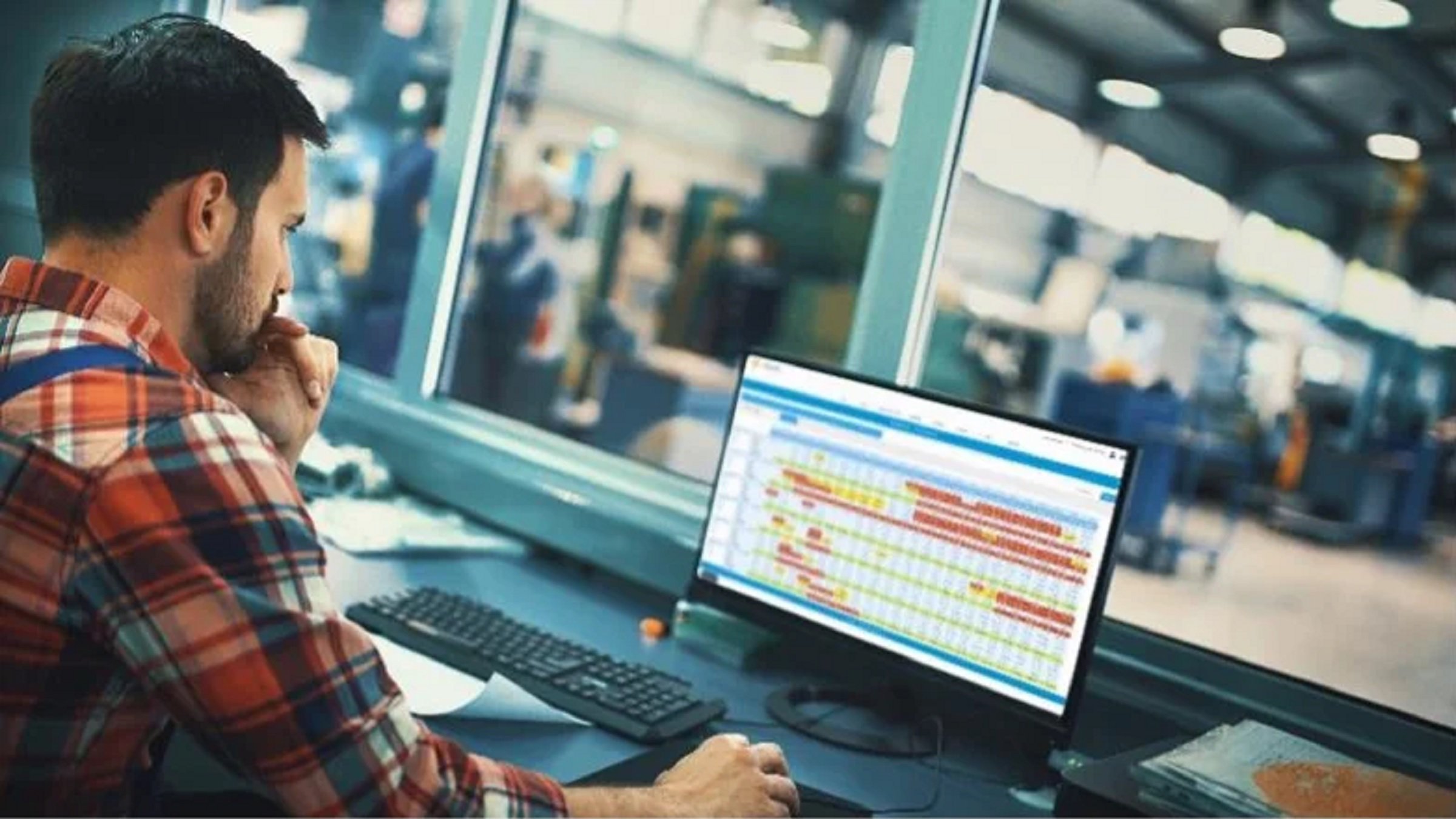 Staff in red plaid shirt using watching screen checking operation status