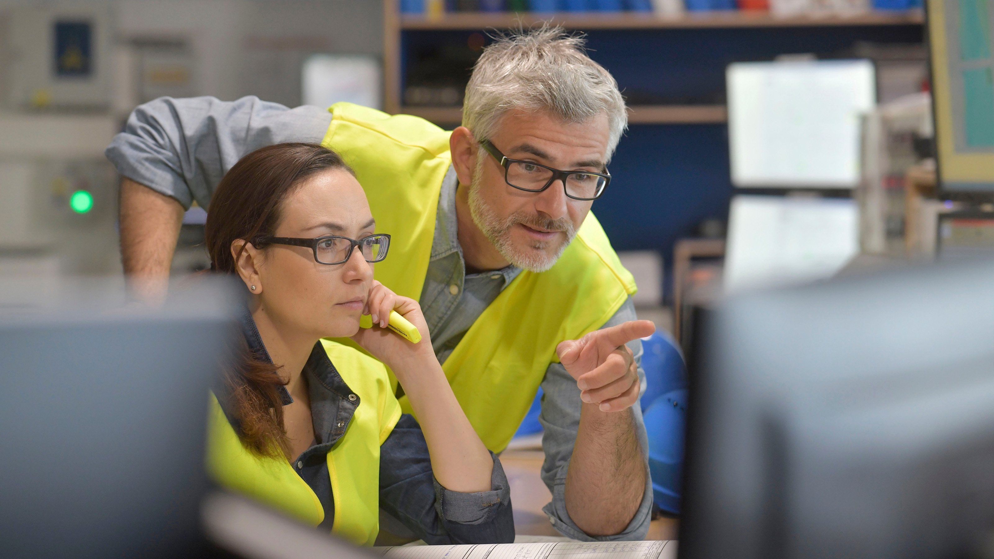 male engineer pointing out something on a monitor to a female engineer