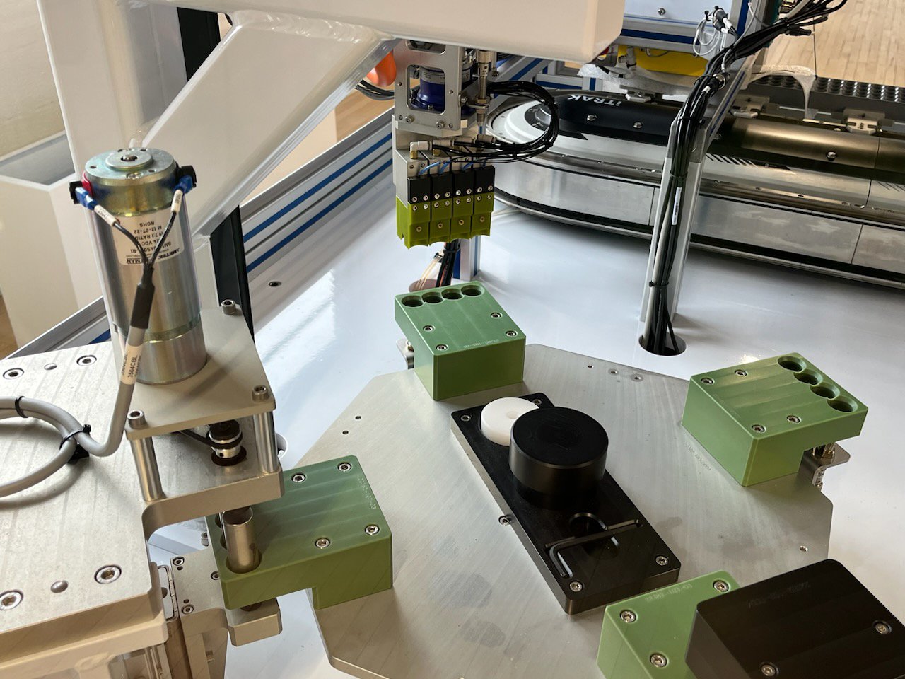 A view inside of a battery assembly machine with an iTRAK Intelligent Track System in the background