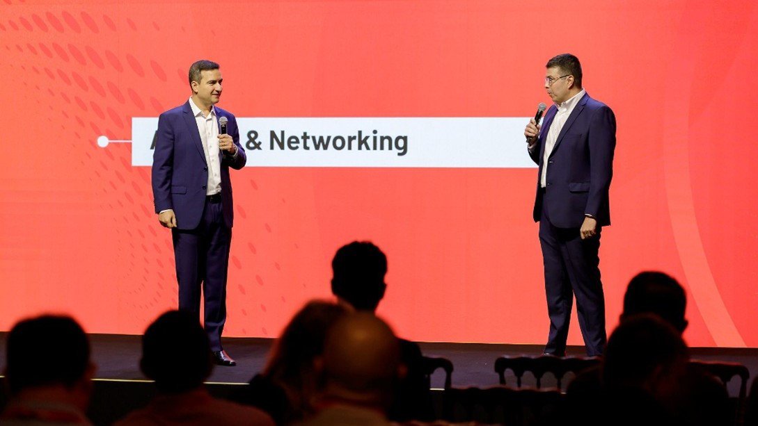 Dois executivos dando uma palestra no palco