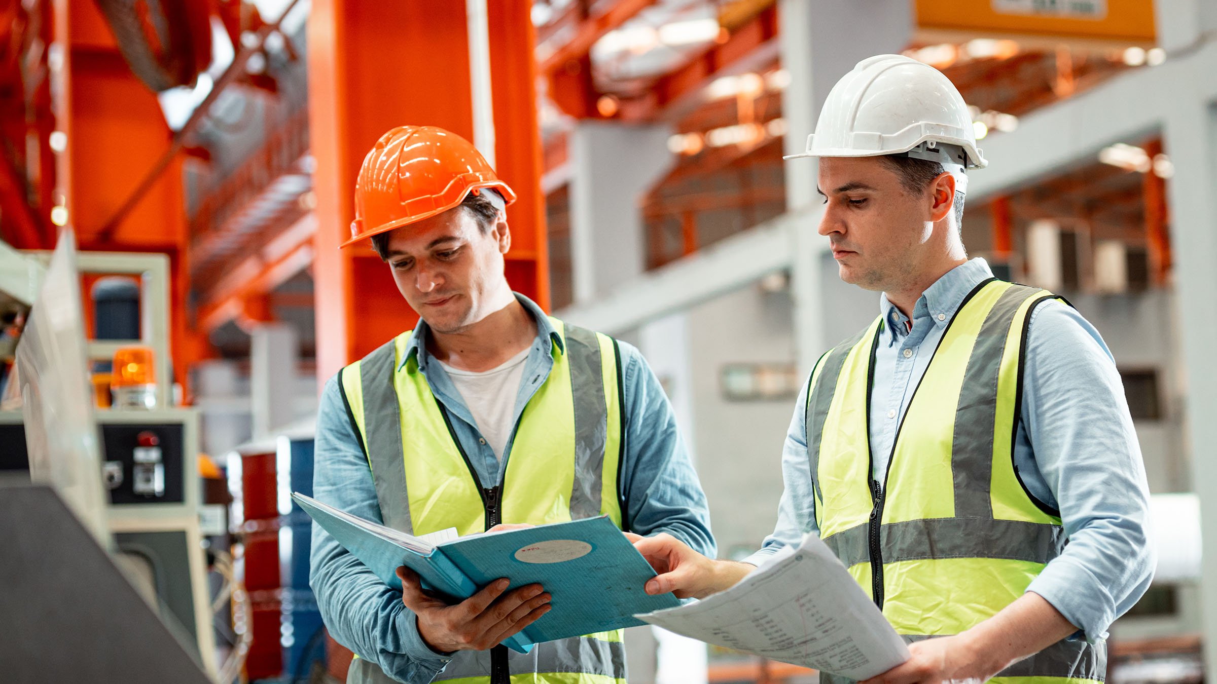 Factory workers in PPE looking at paperwork