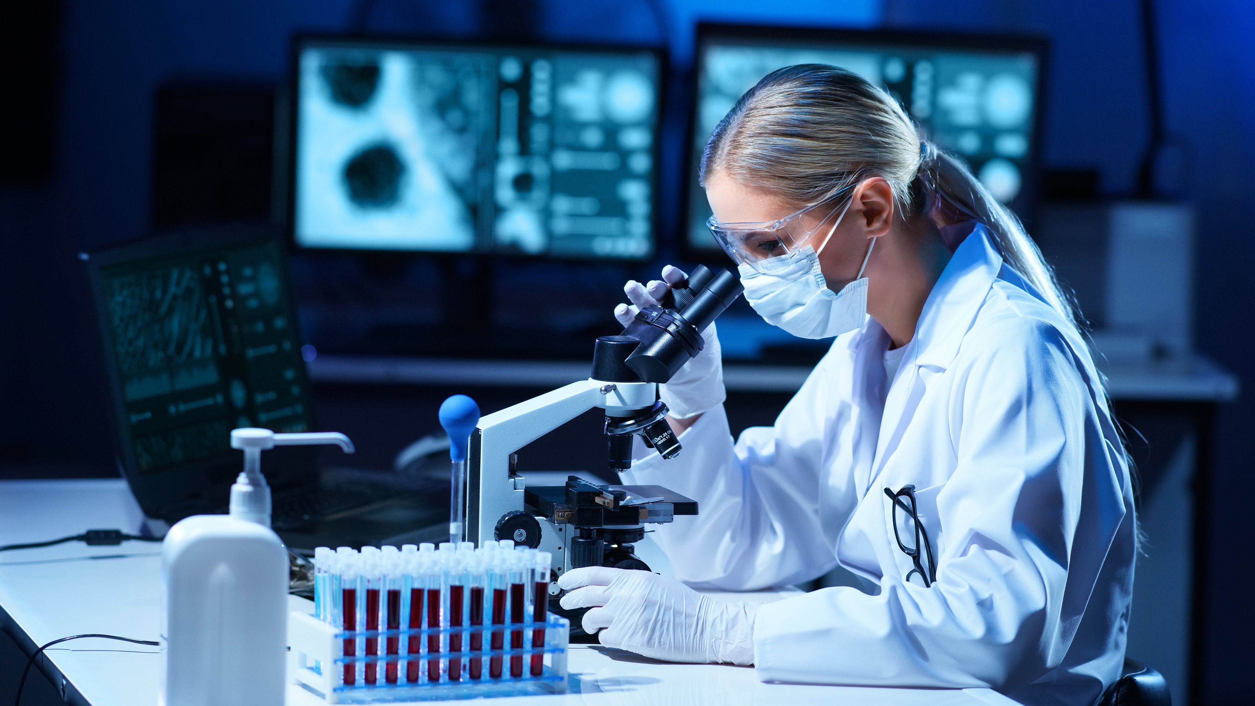 Female scientist working in modern lab. Doctor making microbiology research. Laboratory tools: microscope, test tubes, equipment. Coronavirus covid-19, bacteriology, virology, dna and health care.