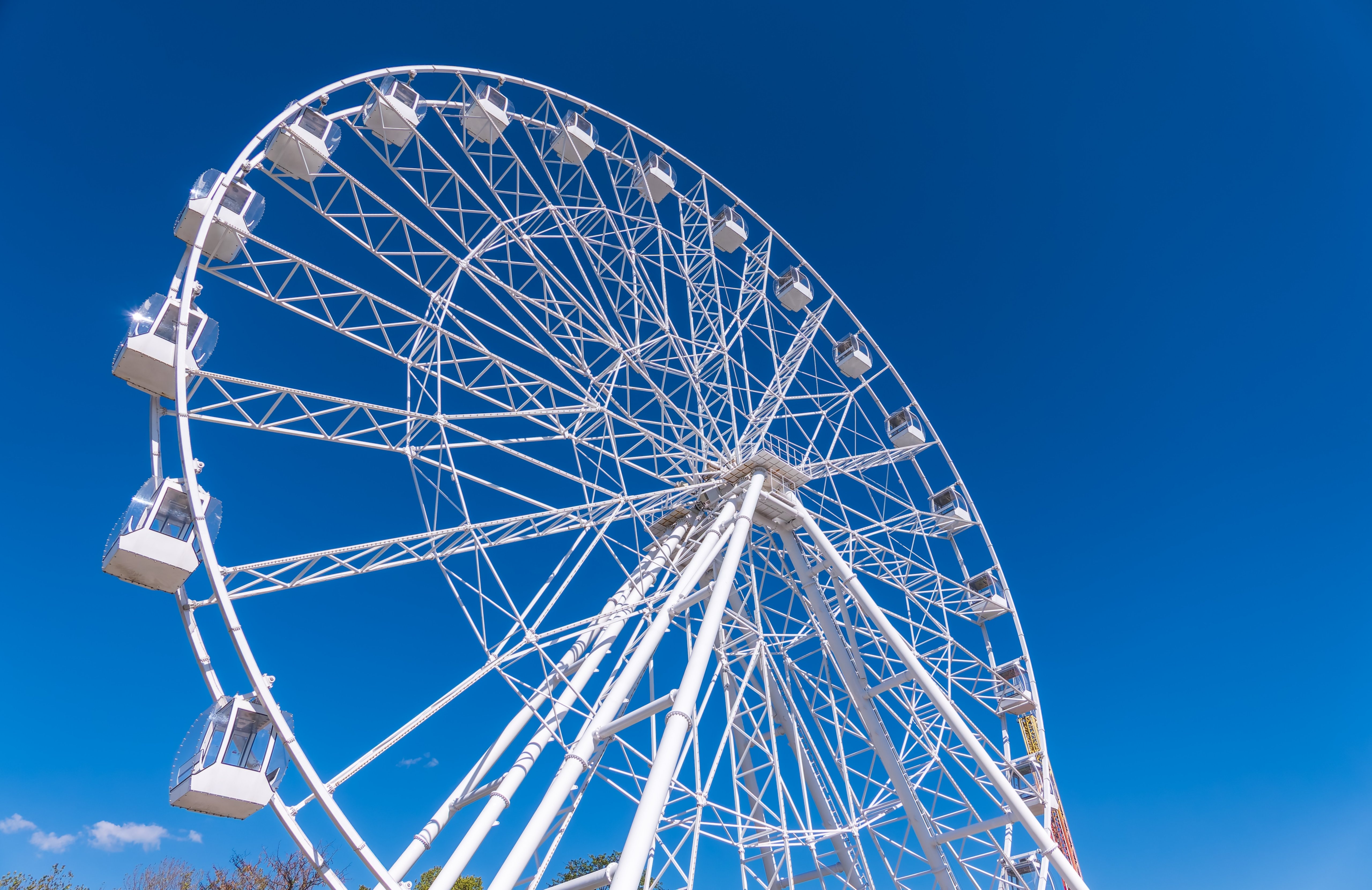Ferris wheel under blue sky, capturing fun and adventure on a sunny day. Ferris wheel at the amusement park adjacent to the hotel