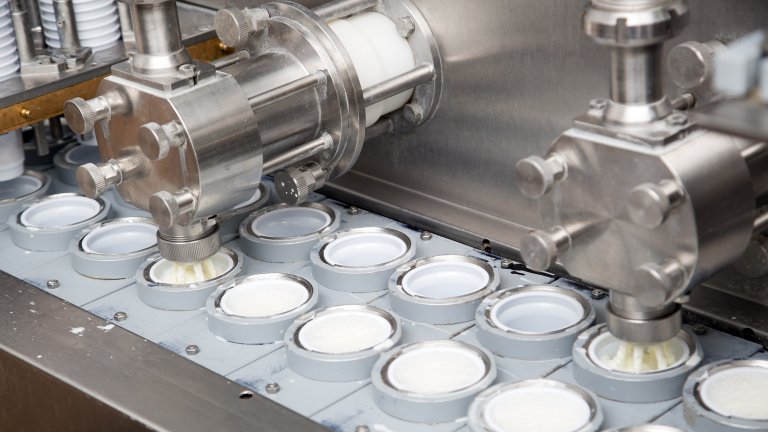 Final Stage Of Production Yogurt-Filling Yogurt Into Plastic Glasses In Modern Dairy.