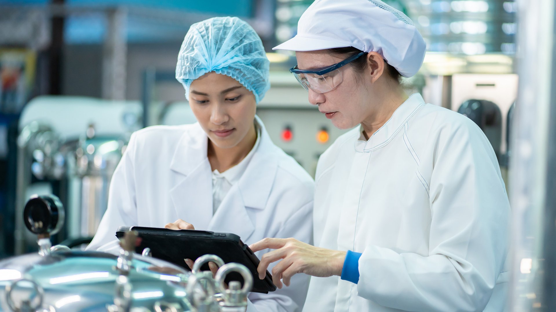 Two workiers looking at tablet in food and beverage facility