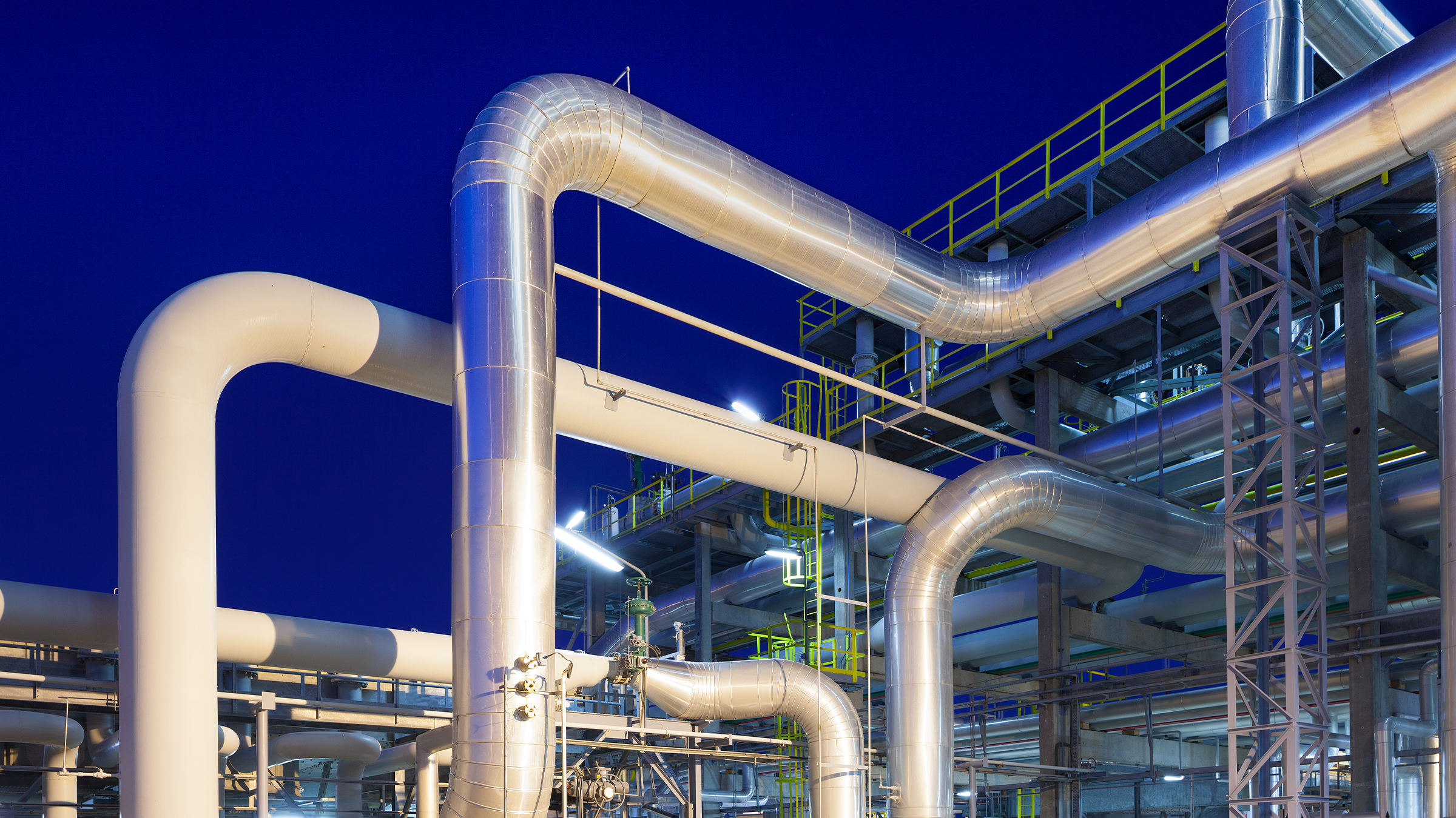 Vista de una planta de refinería de gas iluminada al anochecer