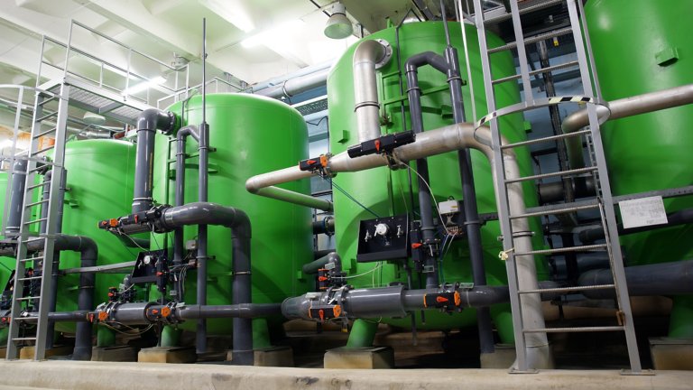 Green water tanks and pipes inside a power plant