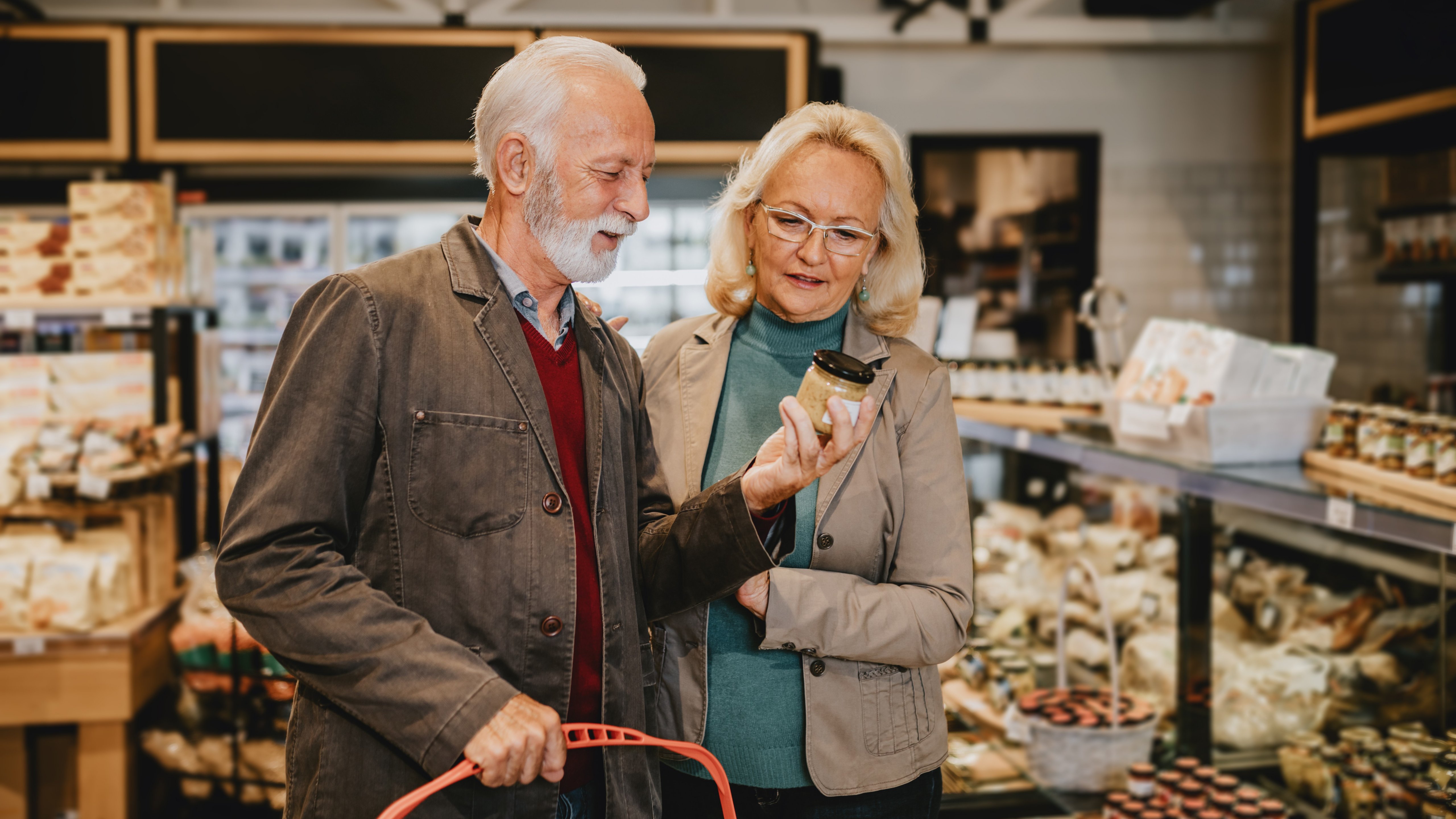 Happy senior couple shopping in grocery store or supermarket Consumerism concept