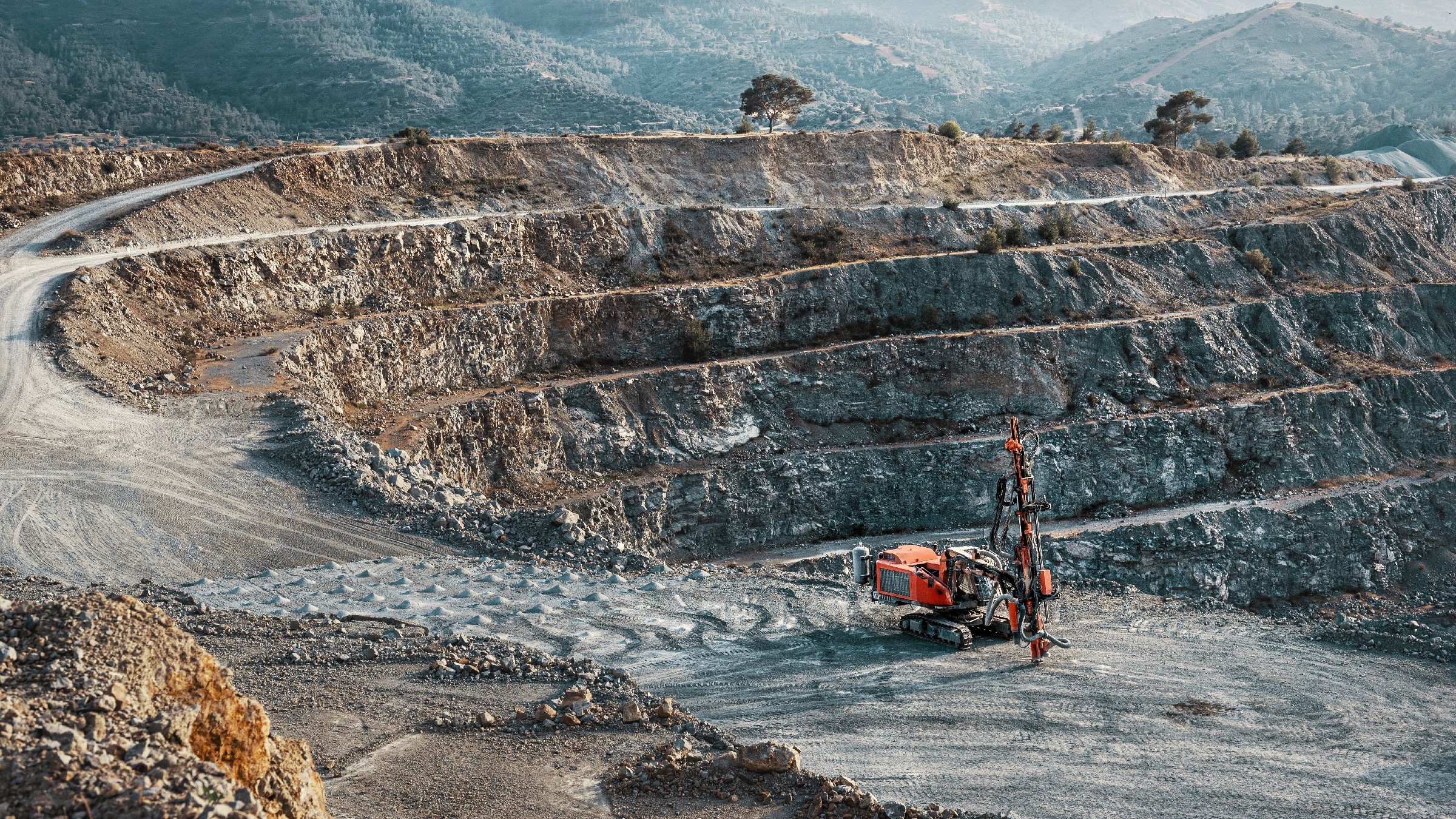 Industrial landscape with red stone crusher machine in gravel quarry.