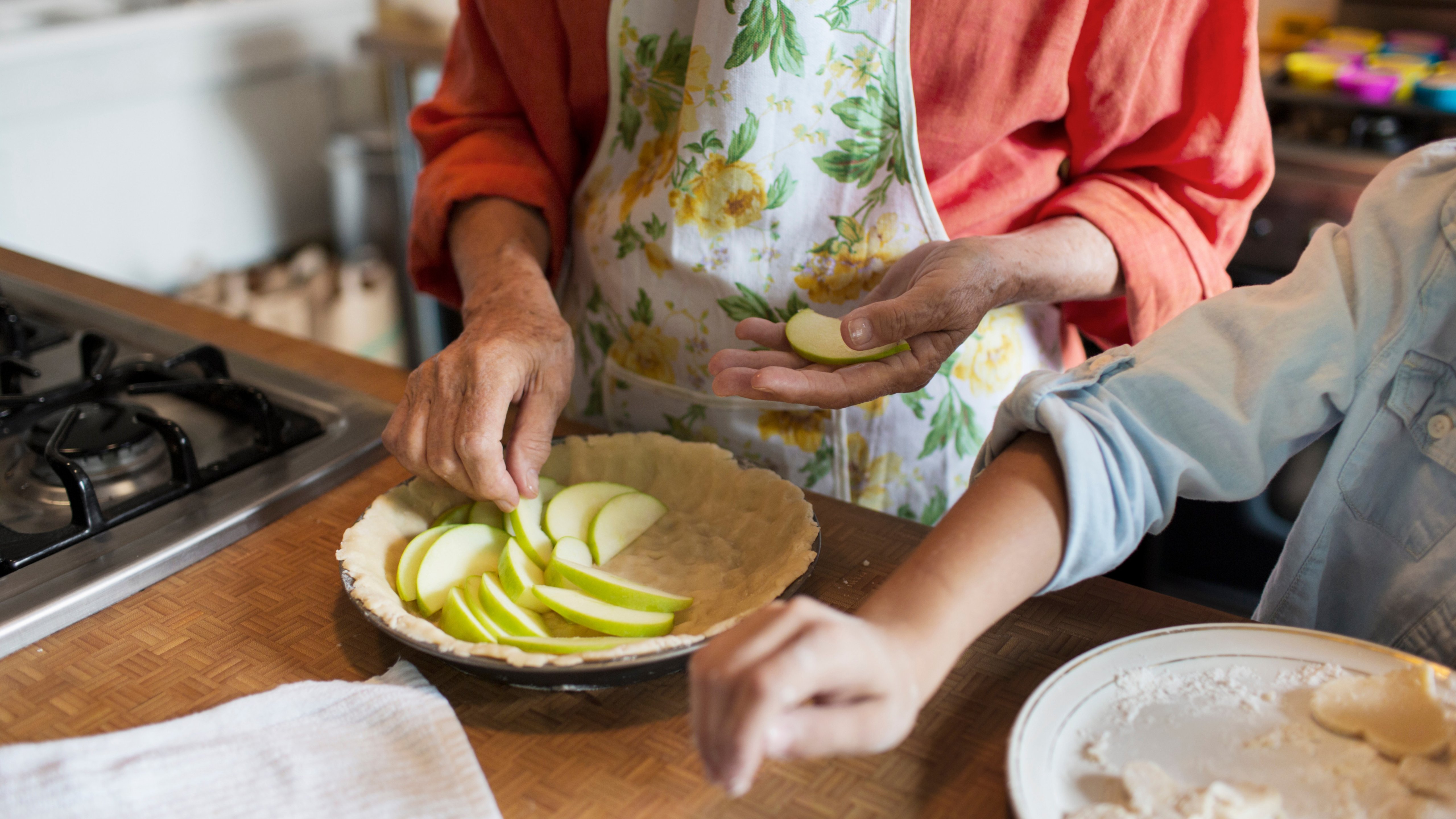 grandparent making apple pie with grandchild
