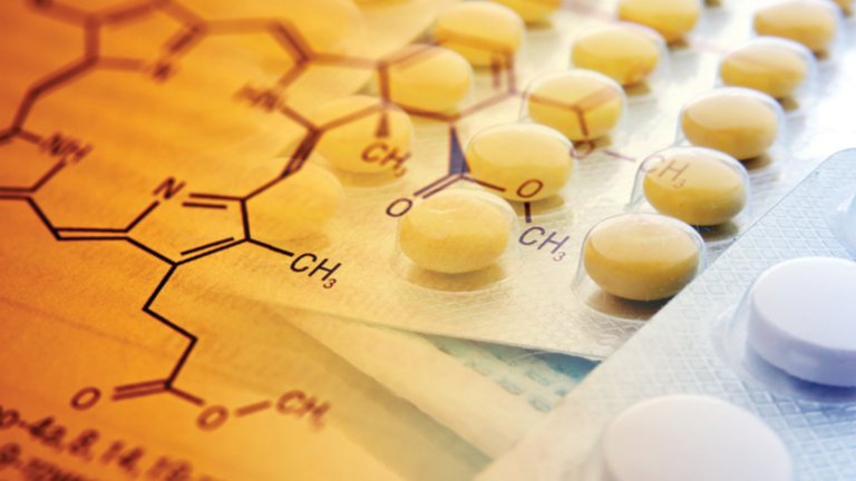 Grafiken, die chemische Verbindungen darstellen, überdecken zwei Blasenverpackungen, die mit medizinischen Tabletten gefüllt sind.
