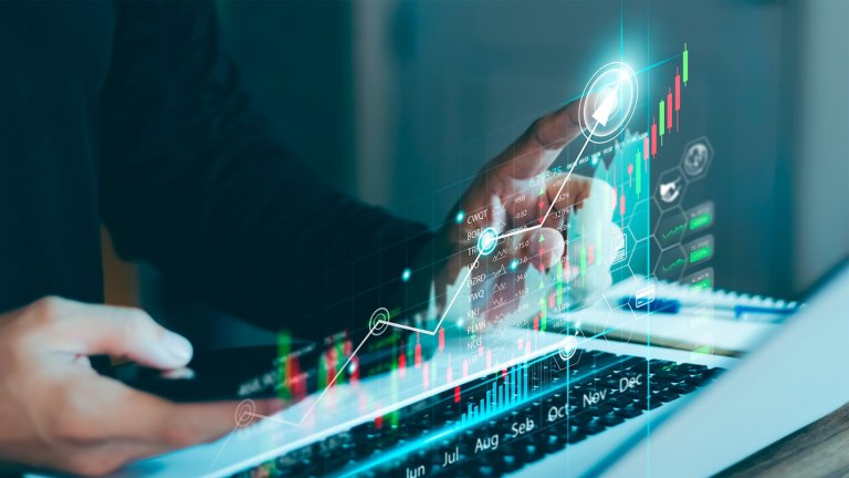 Un hombre analizando gráficos financieros en su computadora portátil