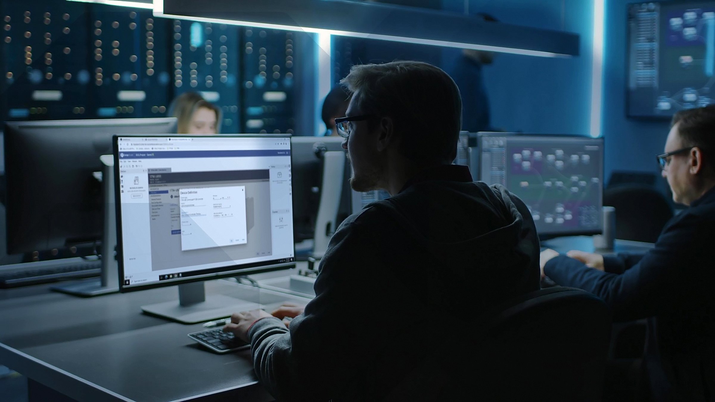A man looks at screen with FactoryTalk Design Studio running on the monitor.