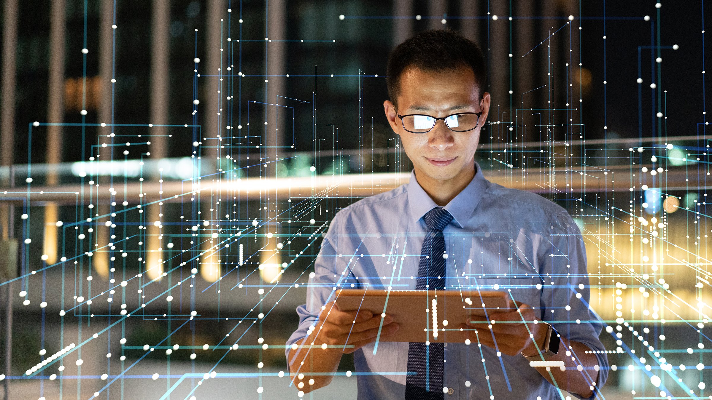 Asian man looking at tablet with network communication graphics