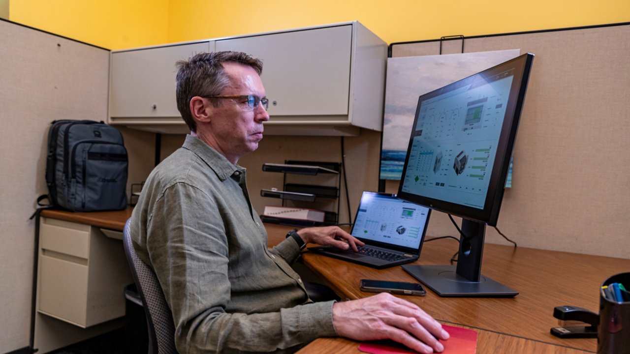 Un uomo che utilizza un software FactoryTalk Optix su un PC mentre sta seduto dietro una scrivania.