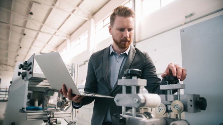 manager checks machines at factory