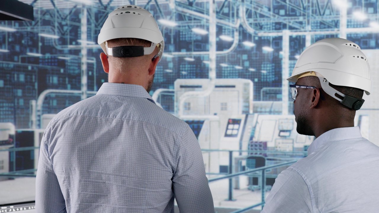 Two men with white hardhats in factory with machine in background. Virtual image graphics.