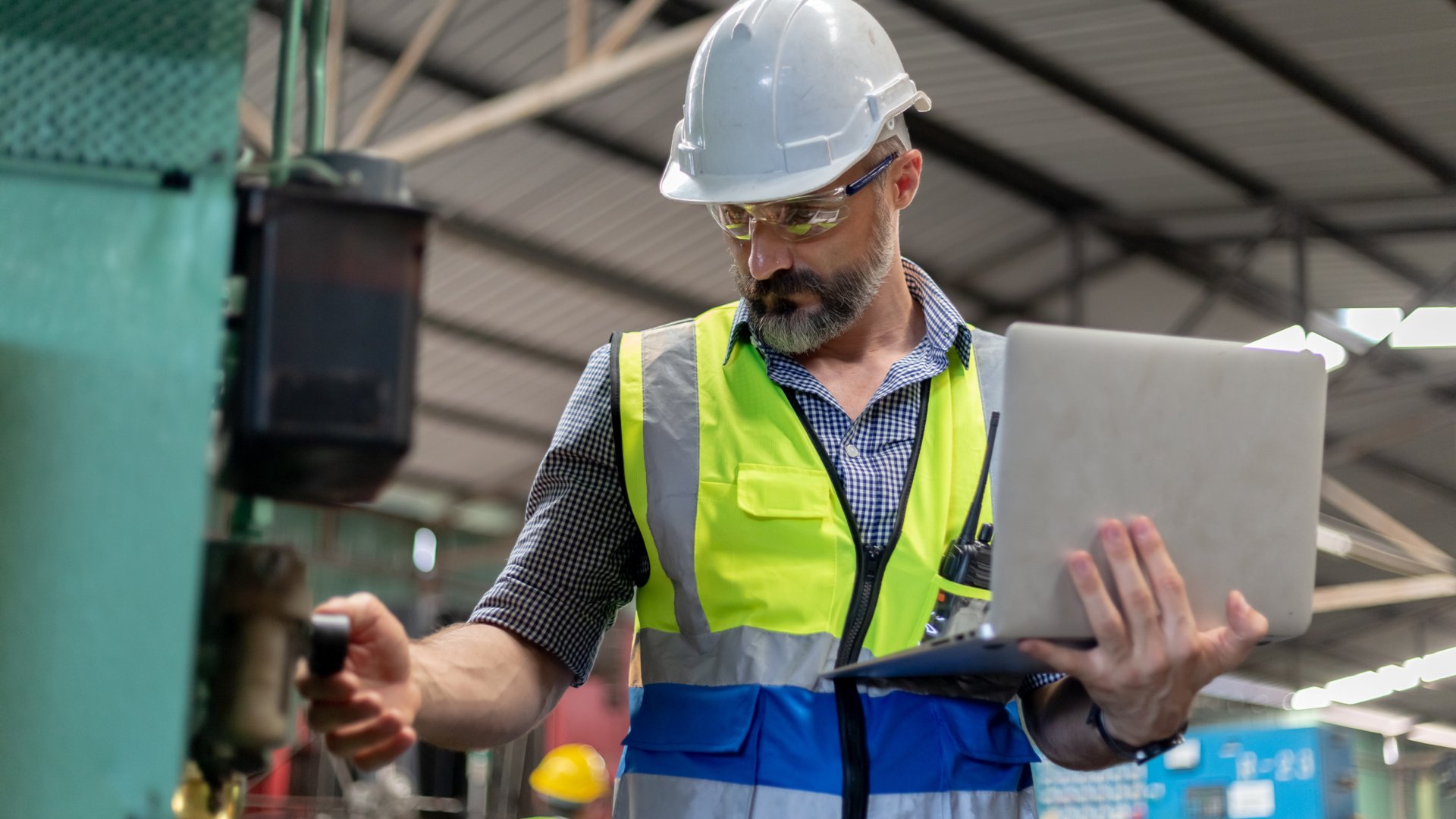 Industrial man engineer wear uniform and helmet using laptop are checking system machine at factory. manager technician manufacturing