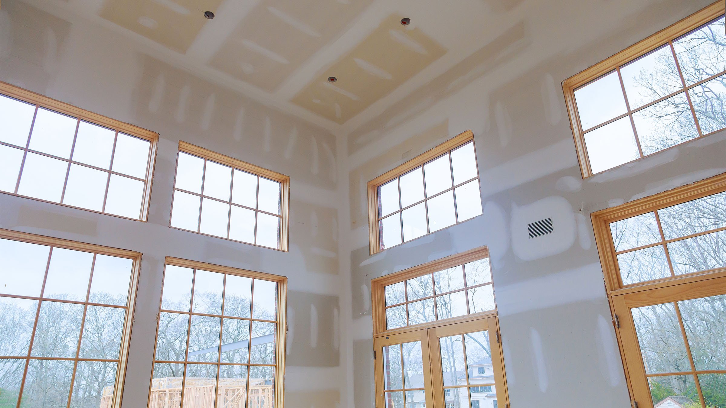 New home construction interior showing drywall and windows from inside looking outward.