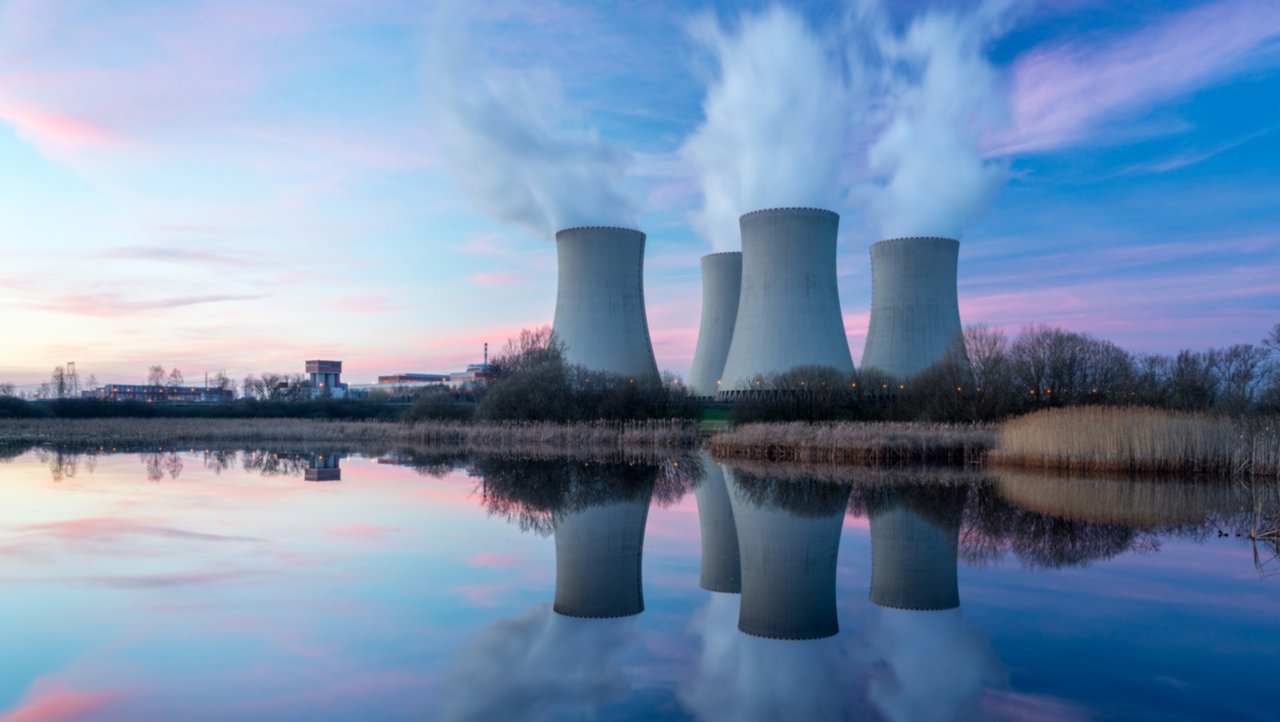 Nuclear power plant after sunset. Dusk landscape with big chimneys.