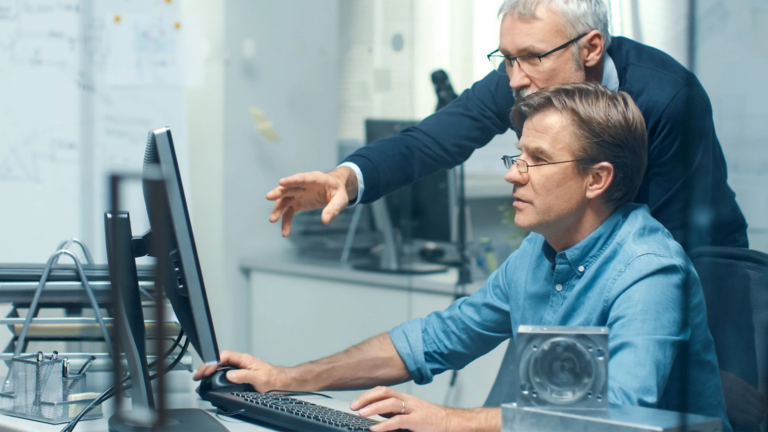 Dos trabajadores frente a una pantalla de computadora