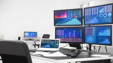 Monitors with stock data on table in office